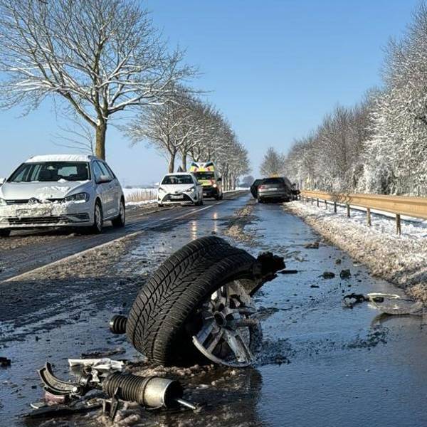 Das Bild zeigt eine verschneite Straße und ein abgerissenes Wagenrad eines Autos auf der Fahrbahn.