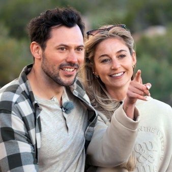 Ein Mann und eine Frau sitzen nebeneinander. Sie zeigt mit dem Zeigefinger in die Ferne.