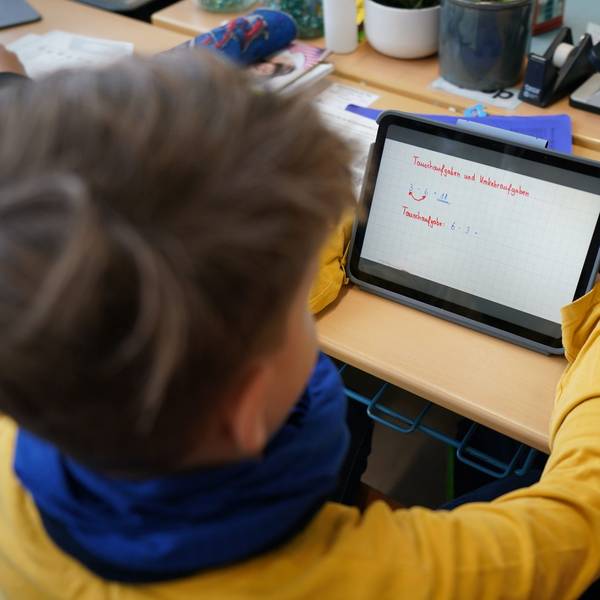 Ein Erstklässler mit einem Tablet in der Klasse.