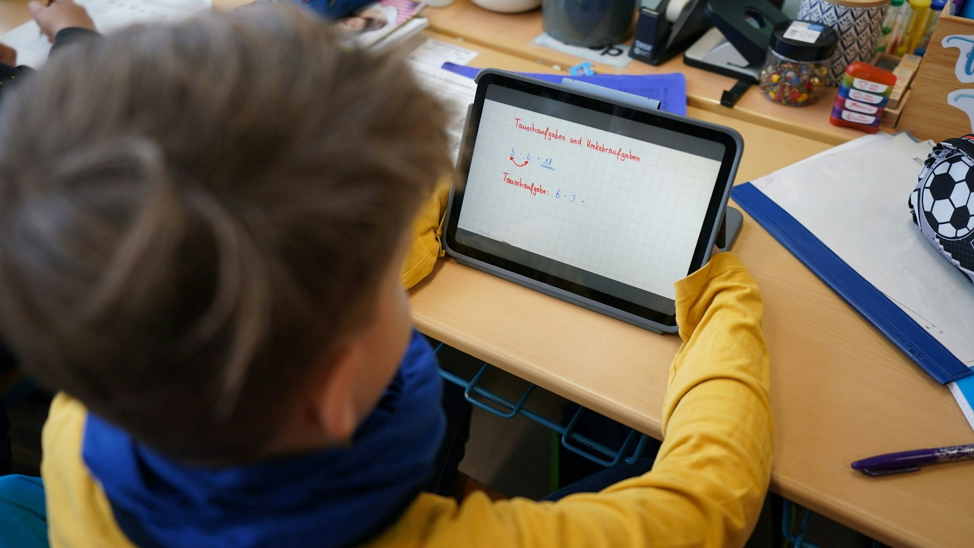 Ein Erstklässler mit einem Tablet in der Klasse.
