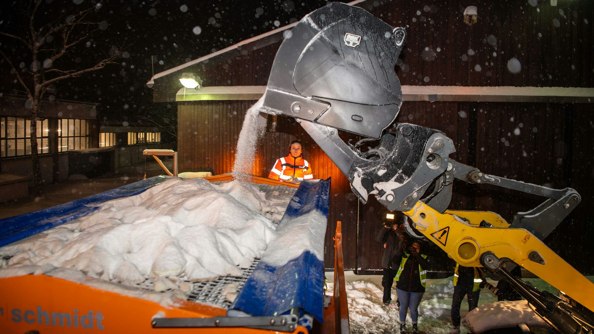 Das Bild zeigt, wie mithilfe eines Radladers das Streusalz in den Auflieger geladen wird.