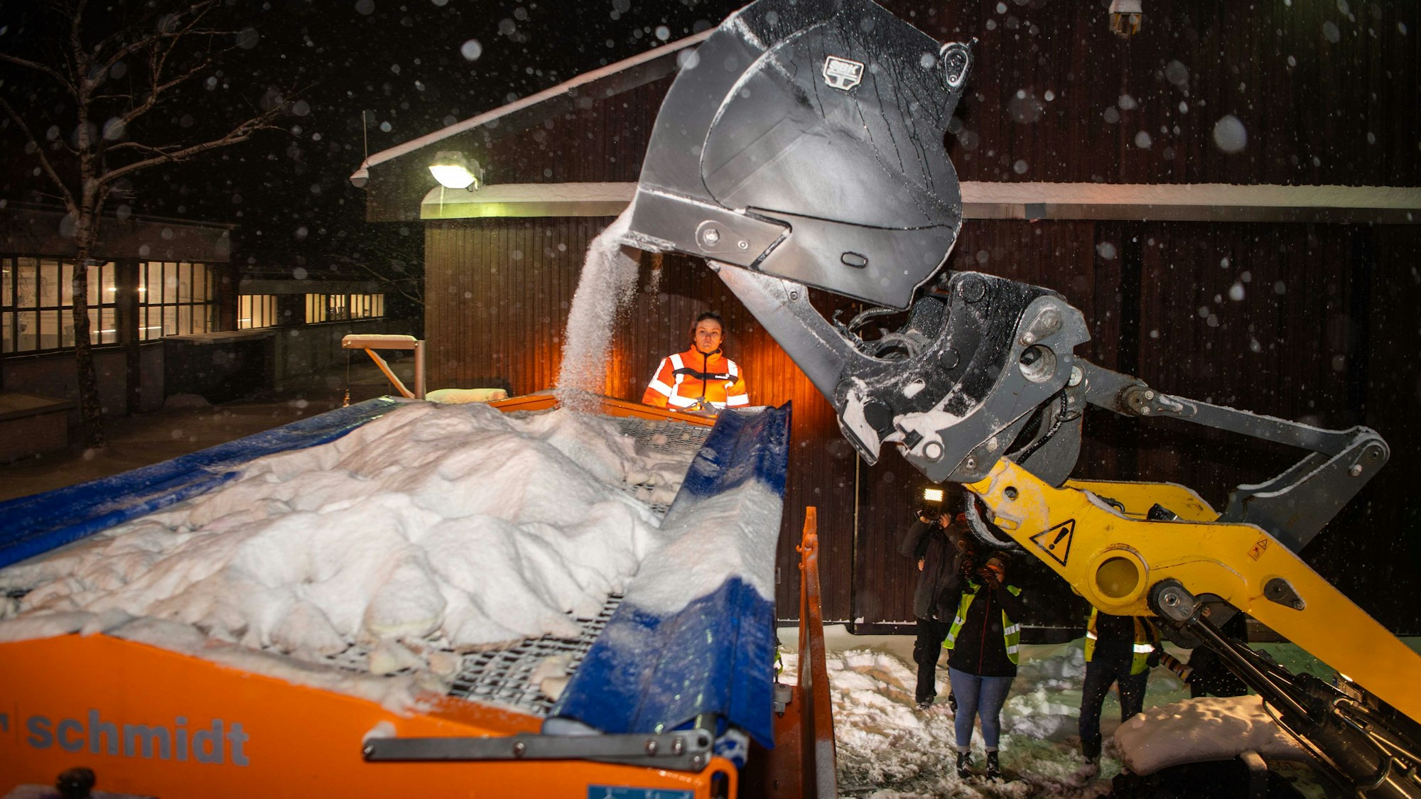 Ein Bagger befördert das Salz aus dem Lager in ein Streufahrzeug.