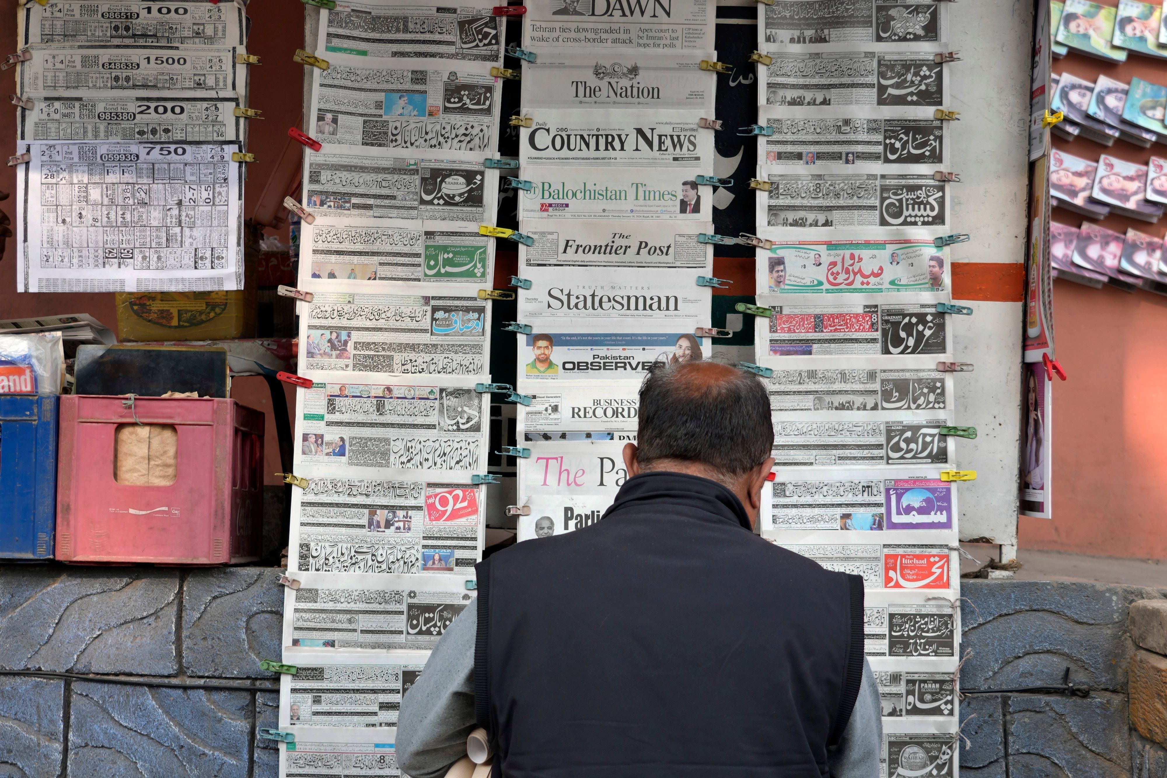 Ein Pakistaner liest an einem Verkaufsstand Tageszeitungen, die auf der Titelseite über den iranischen Angriff berichten.