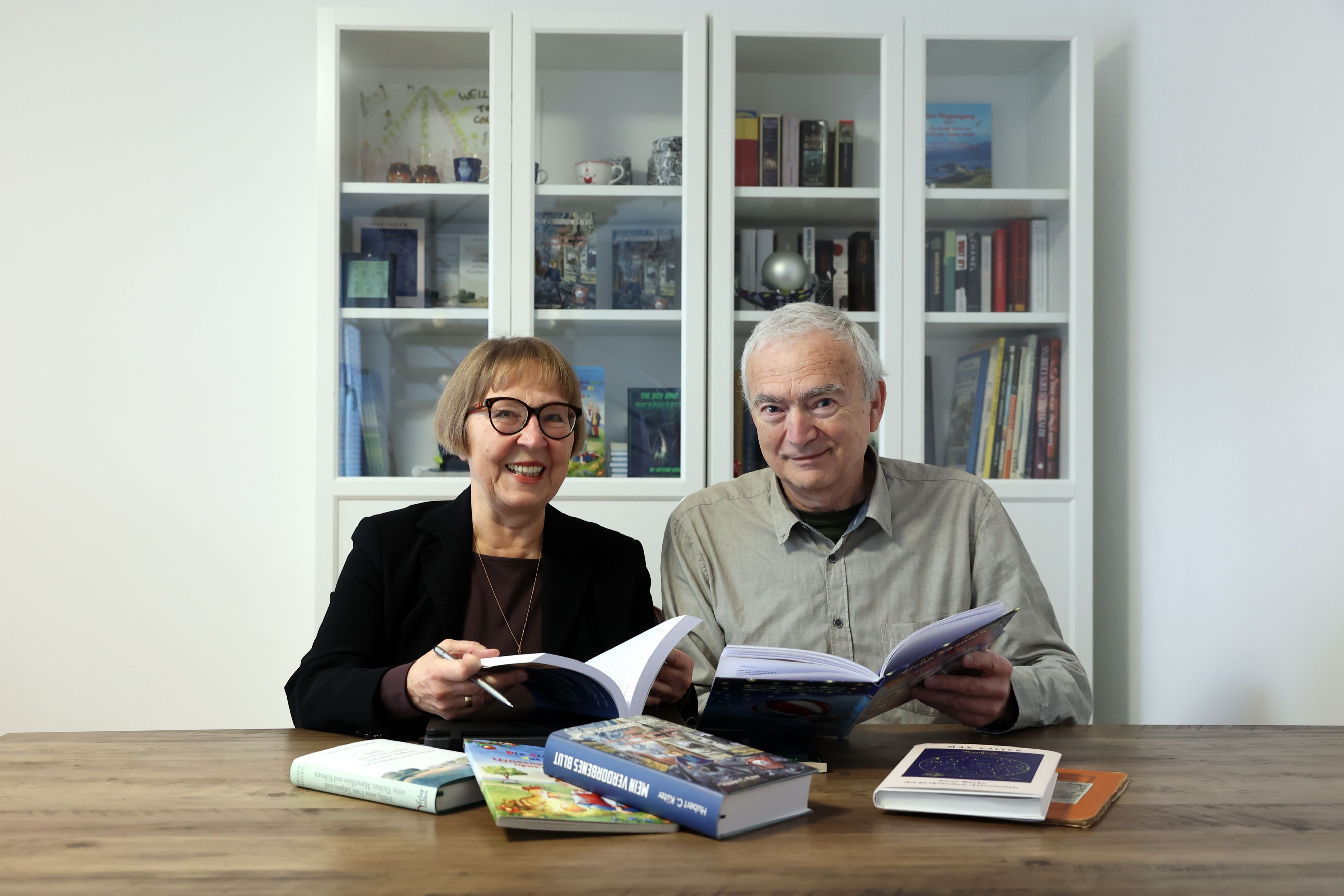 Porträt des Ehepaars Khanin, vor ihnen einige Bücher, die sie verlegt haben.