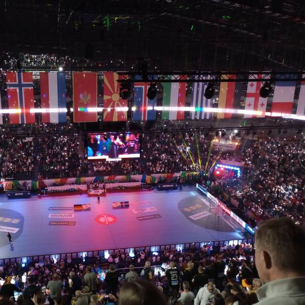 Eine Eventhalle voller Publikum wird bunt ausgeleuchtet.