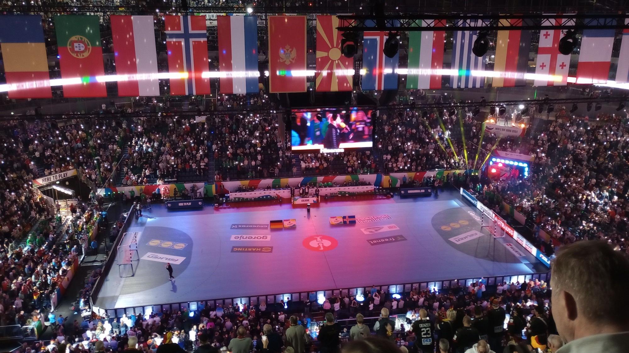 Eine Eventhalle voller Publikum wird bunt ausgeleuchtet.