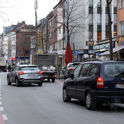 Autos und eine Fahrradfahrerin fahren über die Venloer Straße.