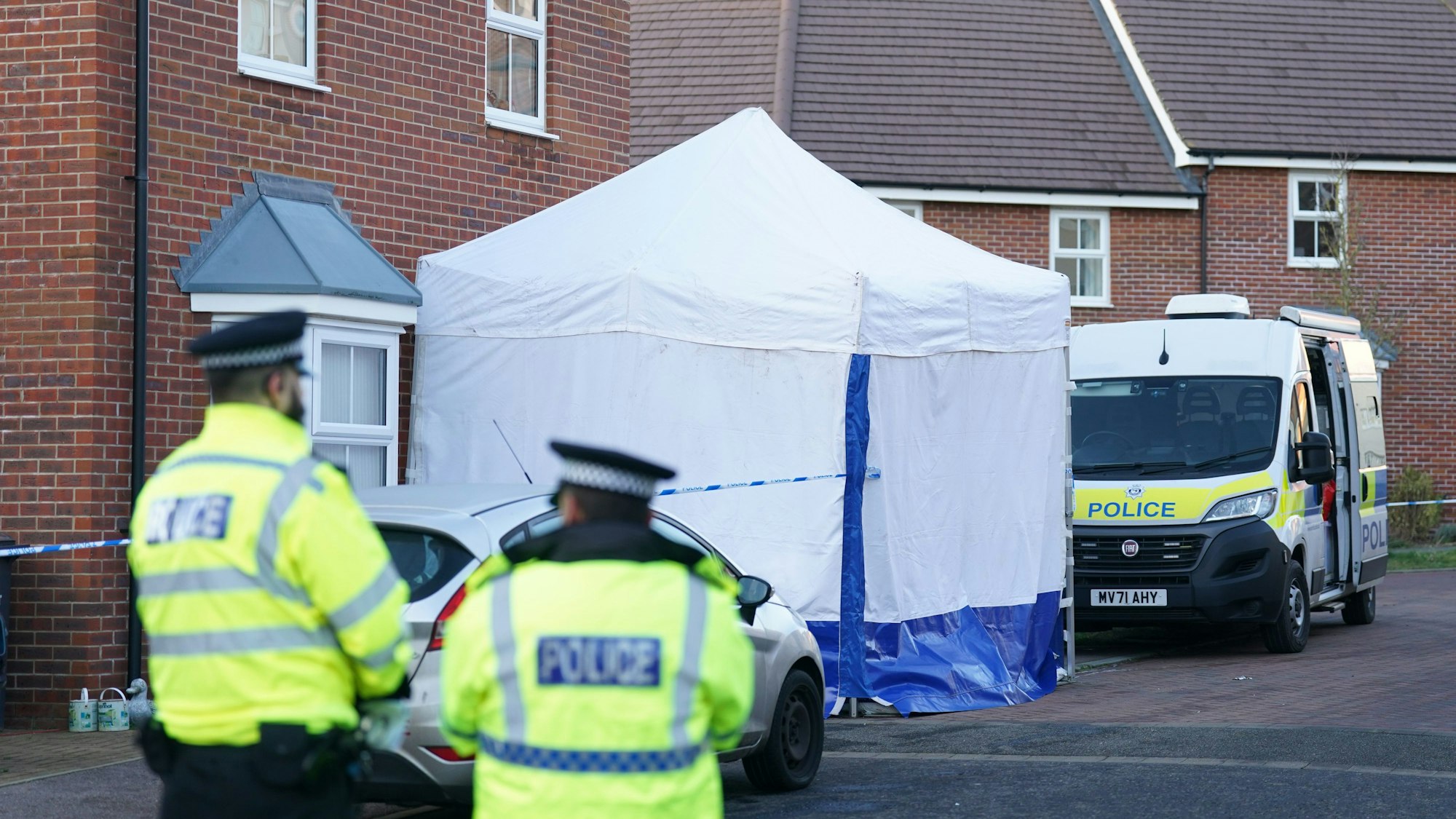 19.01.2024, Großbritannien, Costessey: Polizisten stehen vor dem Tatort.