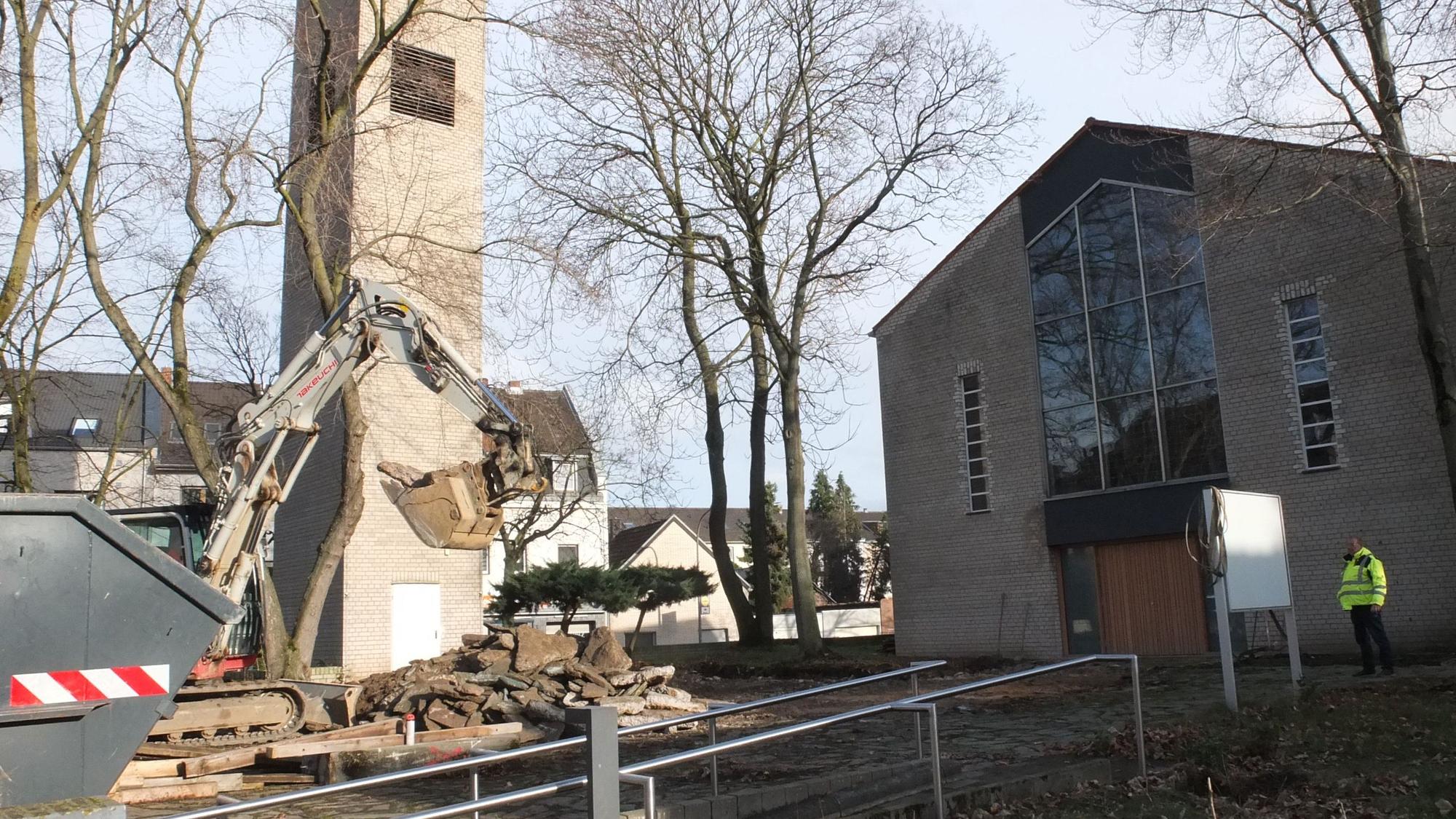 Ein Bagger steht vor einer Kirche.