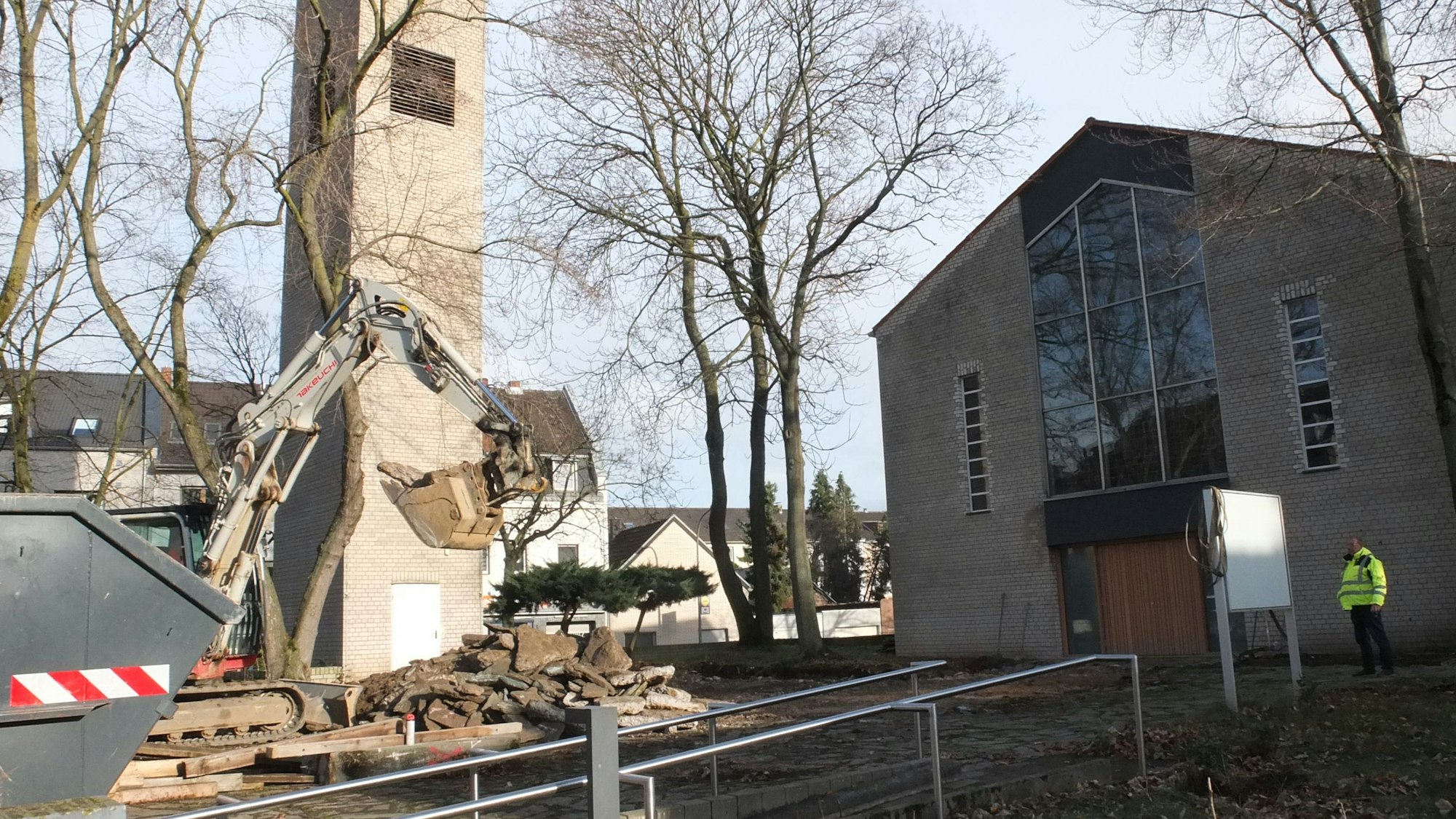 Ein Bagger steht vor einer Kirche.