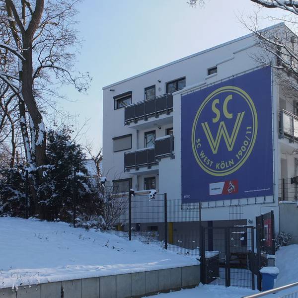 Blick auf ein dreistöckiges Gebäude mit dem Banner des SC West.