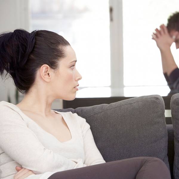 Frau und Mann sitzen zerstritten im Wohnzimmer