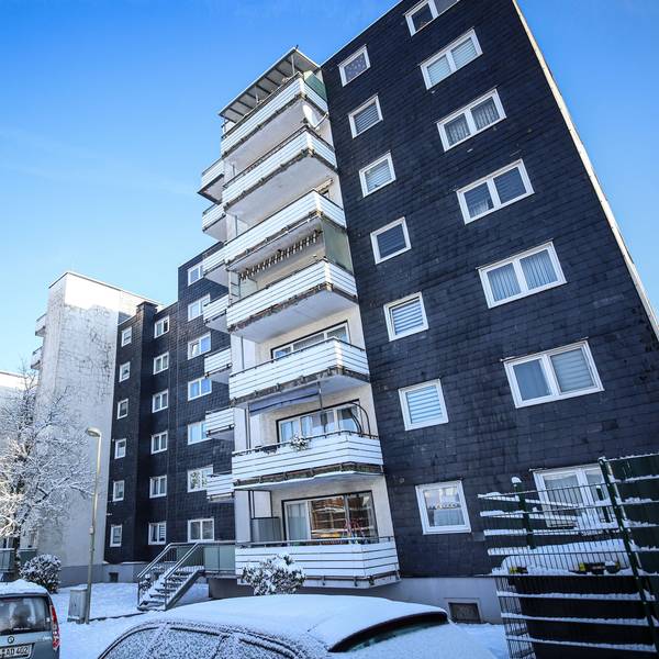 Ein Häuserkomplex mit mehreren Stockwerken und dunkler Fassade in Burscheid.