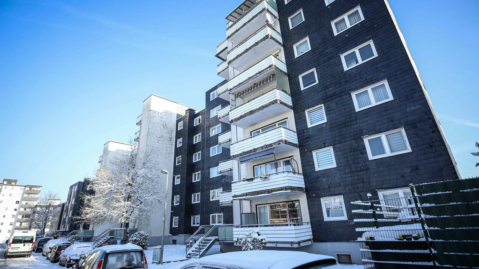 Ein Häuserkomplex mit mehreren Stockwerken und dunkler Fassade in Burscheid.