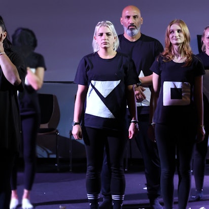 Fünf Inhaftierte in schwarz-weißen Kostümen stehen auf der Bühne der JVA Ossendorf, eine von ihnen muss weinen.