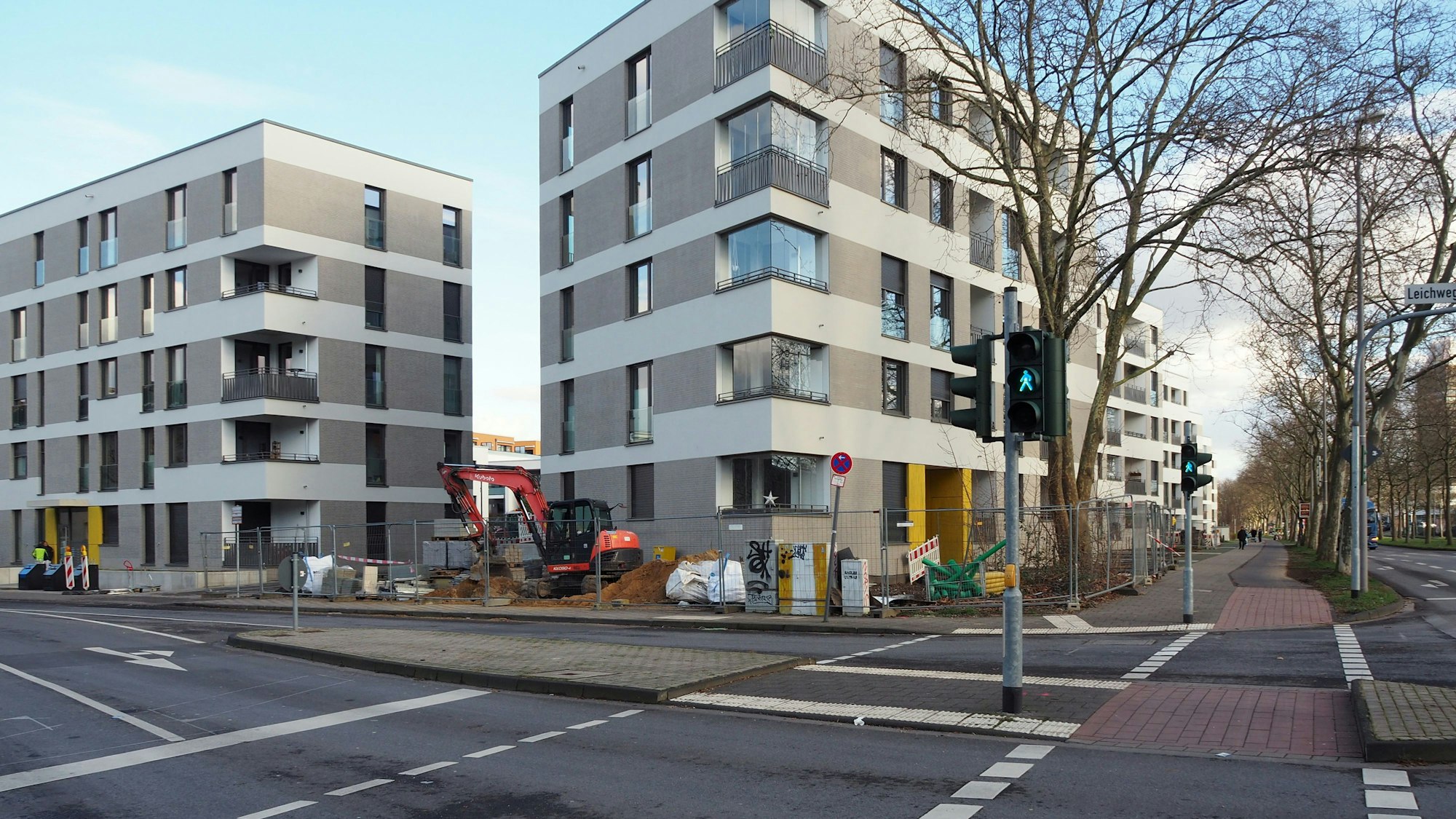 Neue Wohnblöcke, die zum Teil noch mit Bauzäunen abgesperrt sind, liegen direkt an einer großen Kreuzung.