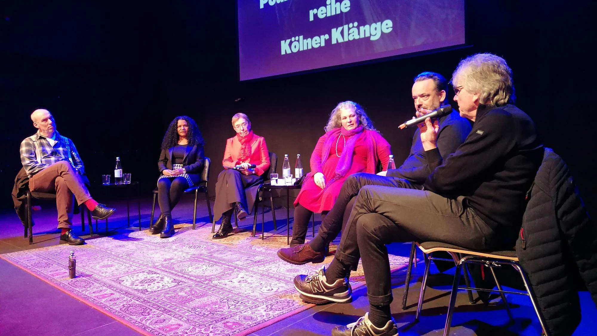 Das Foto zeigt die Teilnehmer der Podiumsdiskussion auf der Bühne.