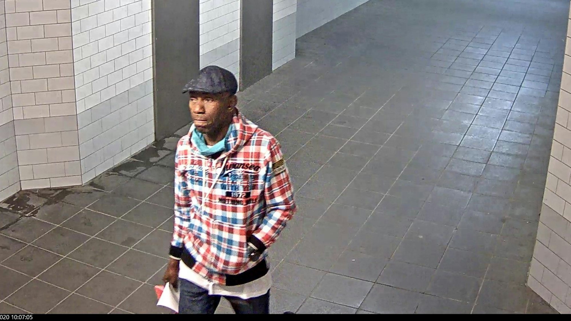 Ein Mann in einem bunt karierten Hemd geht durch den Bahnhof Köln-Deutz/Messe.