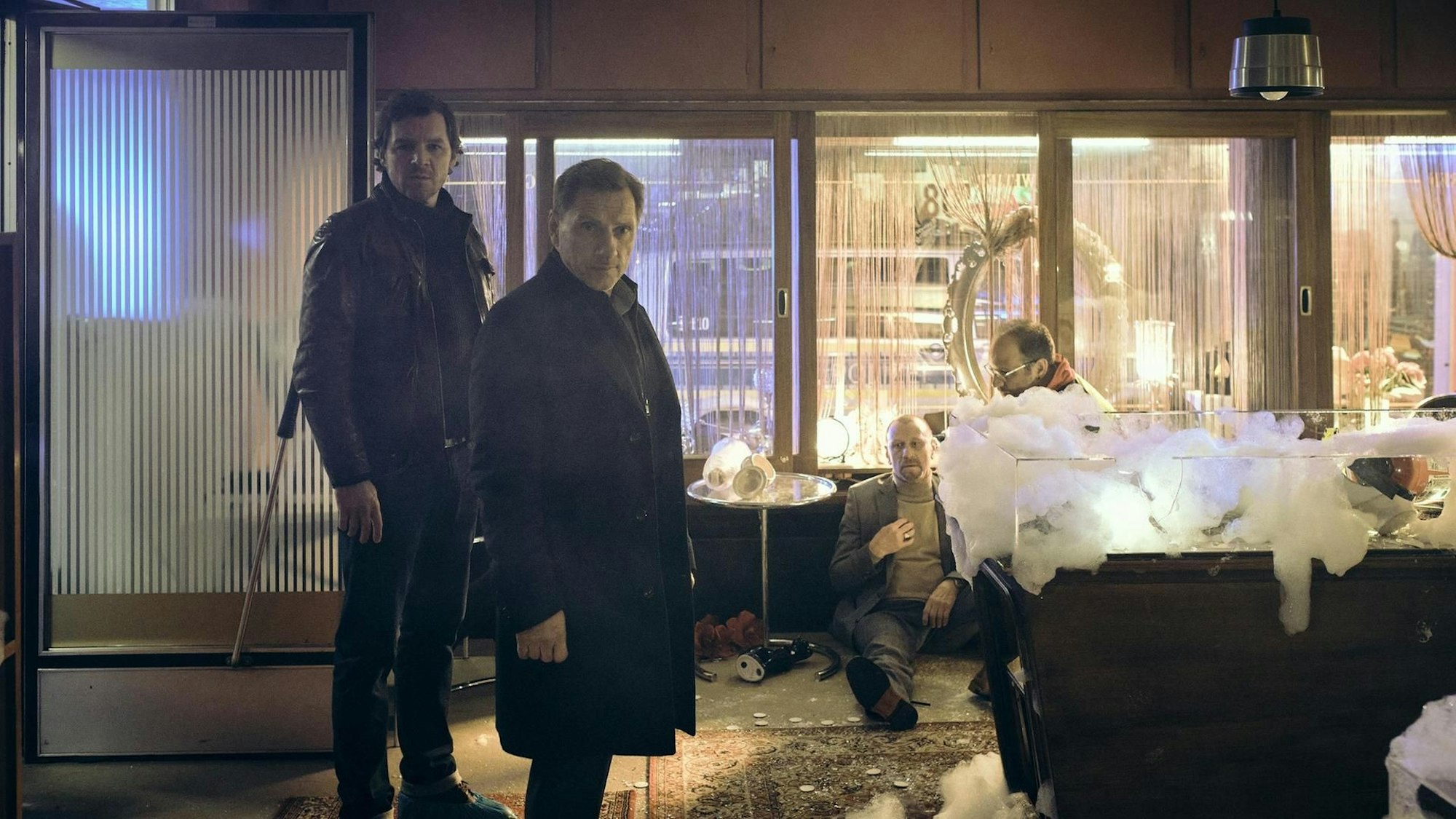 Die beiden Kommissare stehen am Tatort, einem verwüsteten Juweliergeschäft.