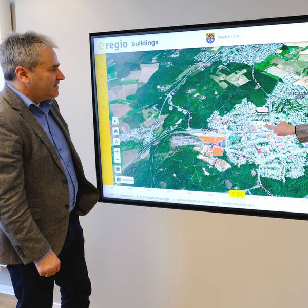 Geschäftsführer Markus Böhm und Mitarbeiterin Miriam Stork vom Euskirchener Energieversorger e-regio vor einer Ansicht des digitalen Zwillings zur Erstellung der Kommunalen Wärmeplanung für die Stadt Mechernich.