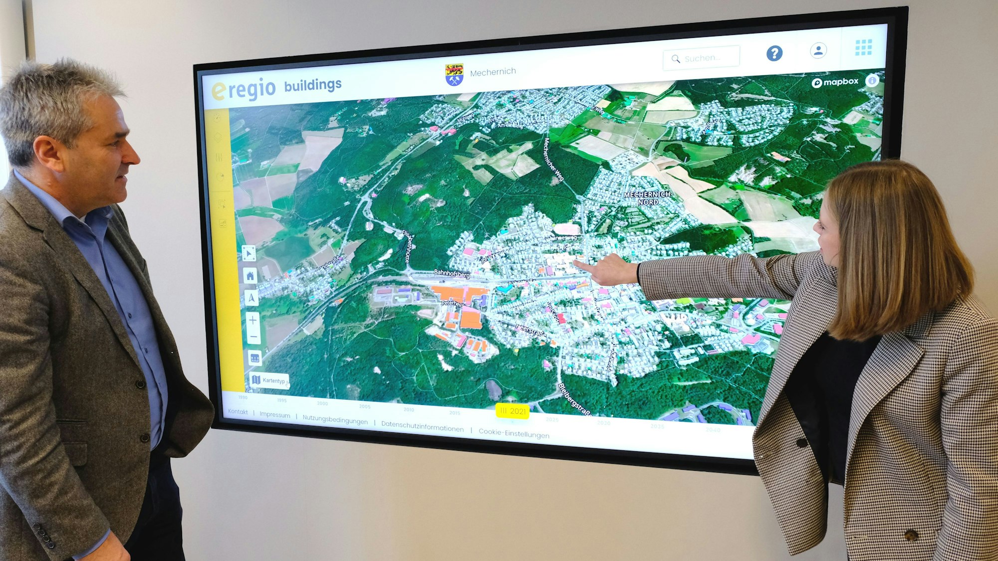 Geschäftsführer Markus Böhm und Mitarbeiterin Miriam Stork vom Euskirchener Energieversorger e-regio vor einer Ansicht des digitalen Zwillings zur Erstellung der Kommunalen Wärmeplanung für die Stadt Mechernich.