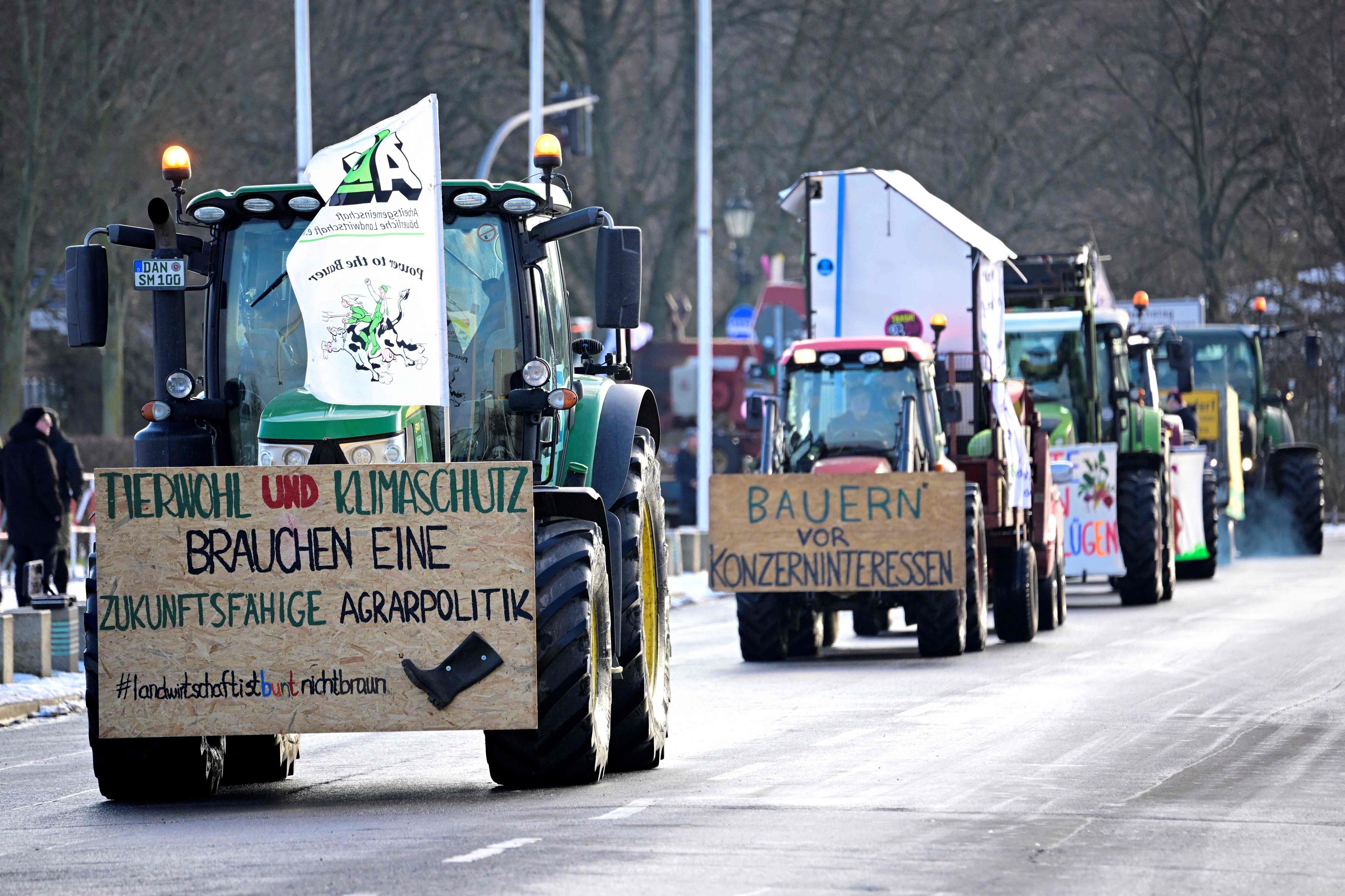 Farmers with their tractors drive near the Reichstag building during a protest under the title 'We are fed up with agricultural industry' against industrial food production in Berlin, Germany on January 20, 2024. The lettering on the board left reads 'Animal welfare and climate protection need a sustainable agricultural policy'. The demonstration started on January 20 in front of the headquarters of German Social Democratic Party SPD and ended with a rally in front of the Chancellery. (Photo by Tobias SCHWARZ / AFP)
