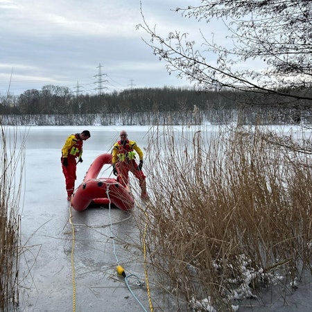Ein Eisrettungsboot mit zwei Feuerwehrleuten auf dem zugefrorenen Otto-Maigler-See.