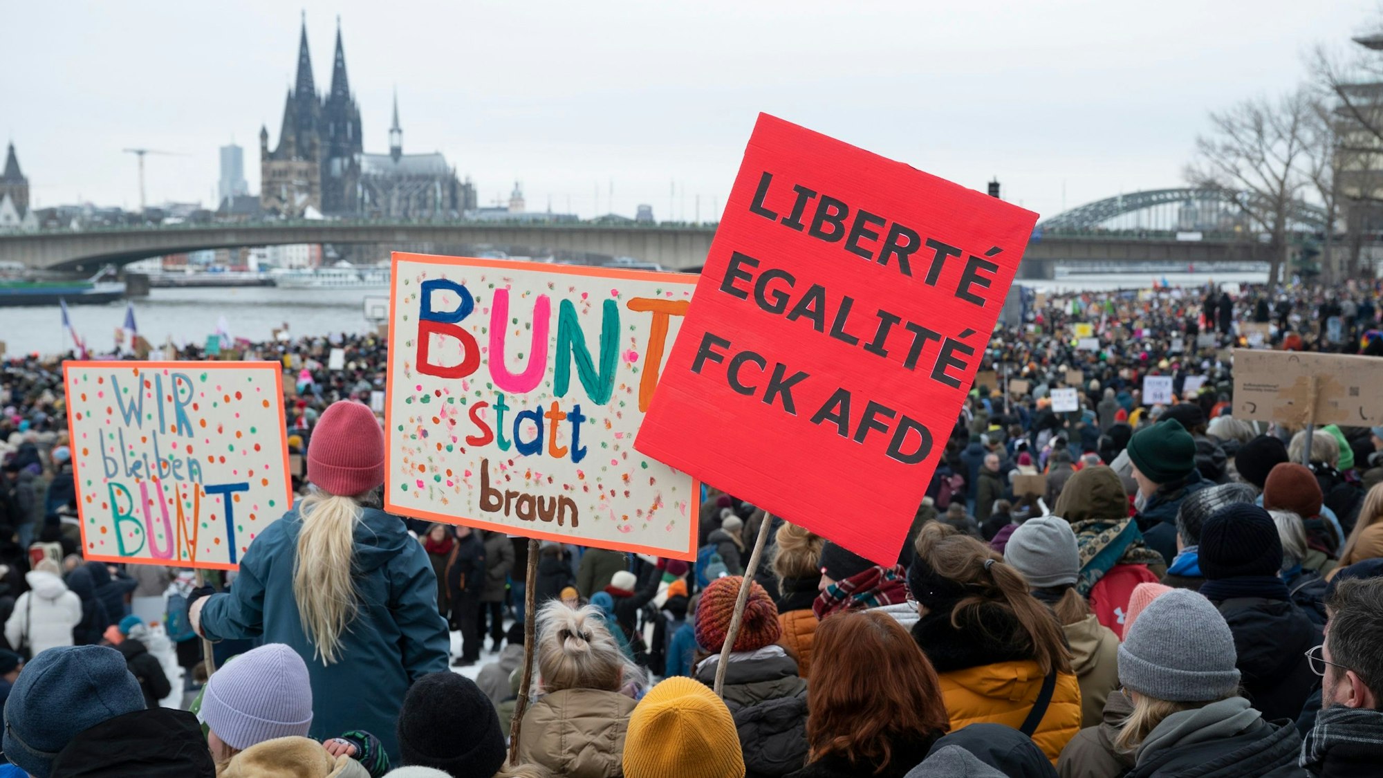 Bei der Großdemo gegen Rechts auf der Deutzer Werft halten Protestierende Plakate mit der Aufschrift „Bunt statt braun“ hoch.