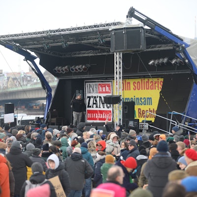 Demonstrierende gegen Rassismus an der Deutzer Werft vor einer Bühne.