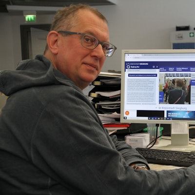 Ein Mann mit Brille an einem PC