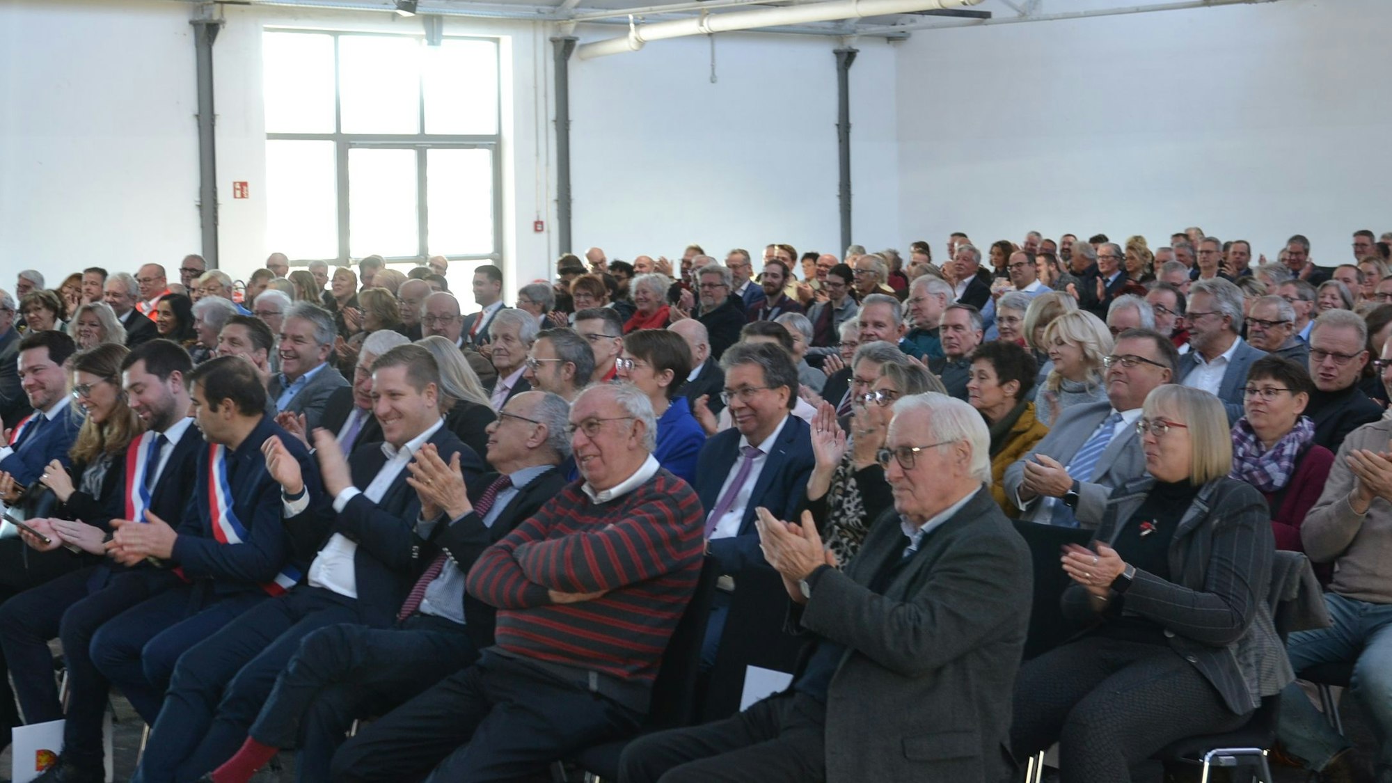 Die Teilnehmer des Neujahrsempfangs applaudieren nach einer Rede.