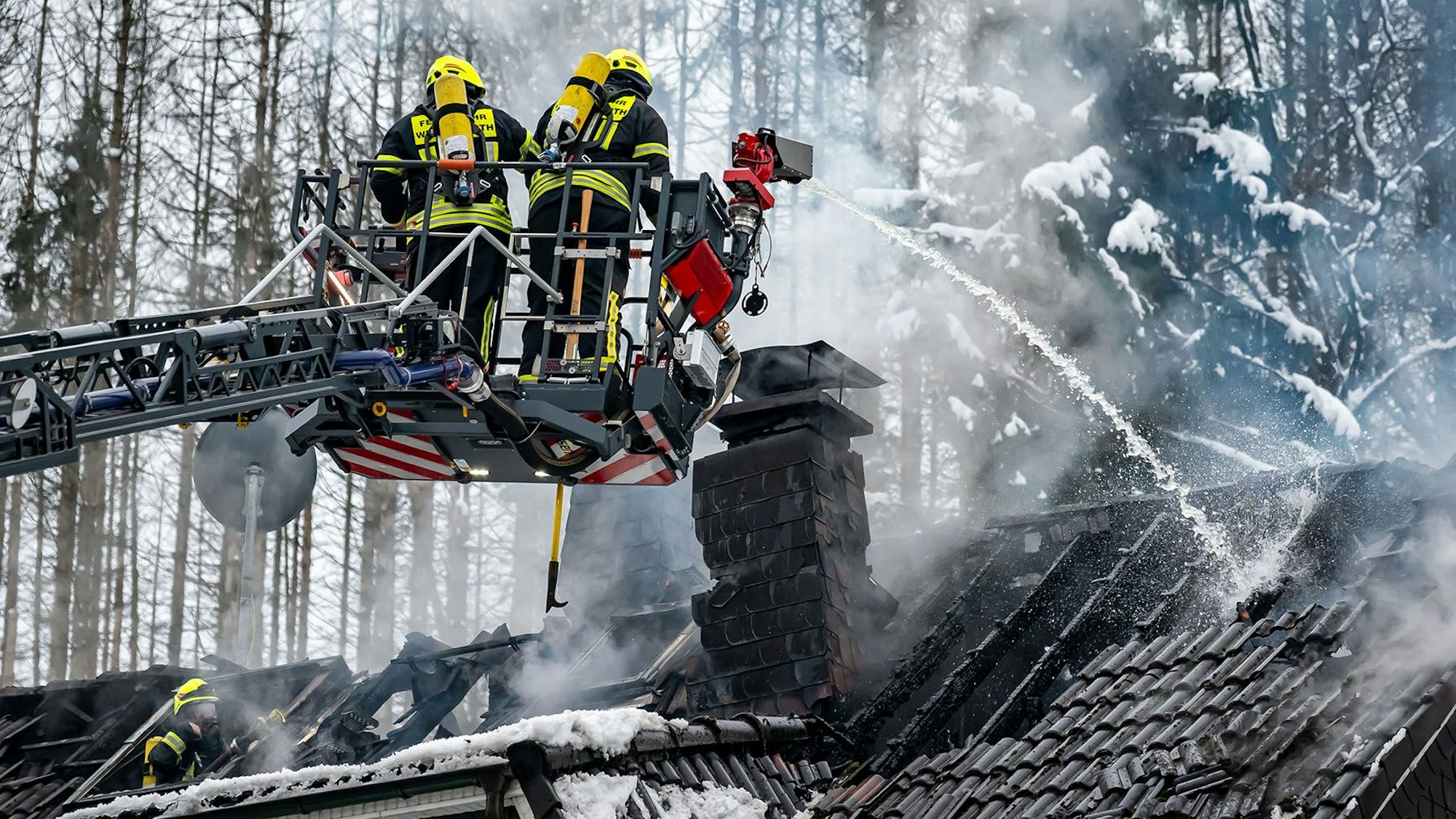 Blick auf Löscharbeiten der Feuerwehr bei einem Dachstuhlbrand.