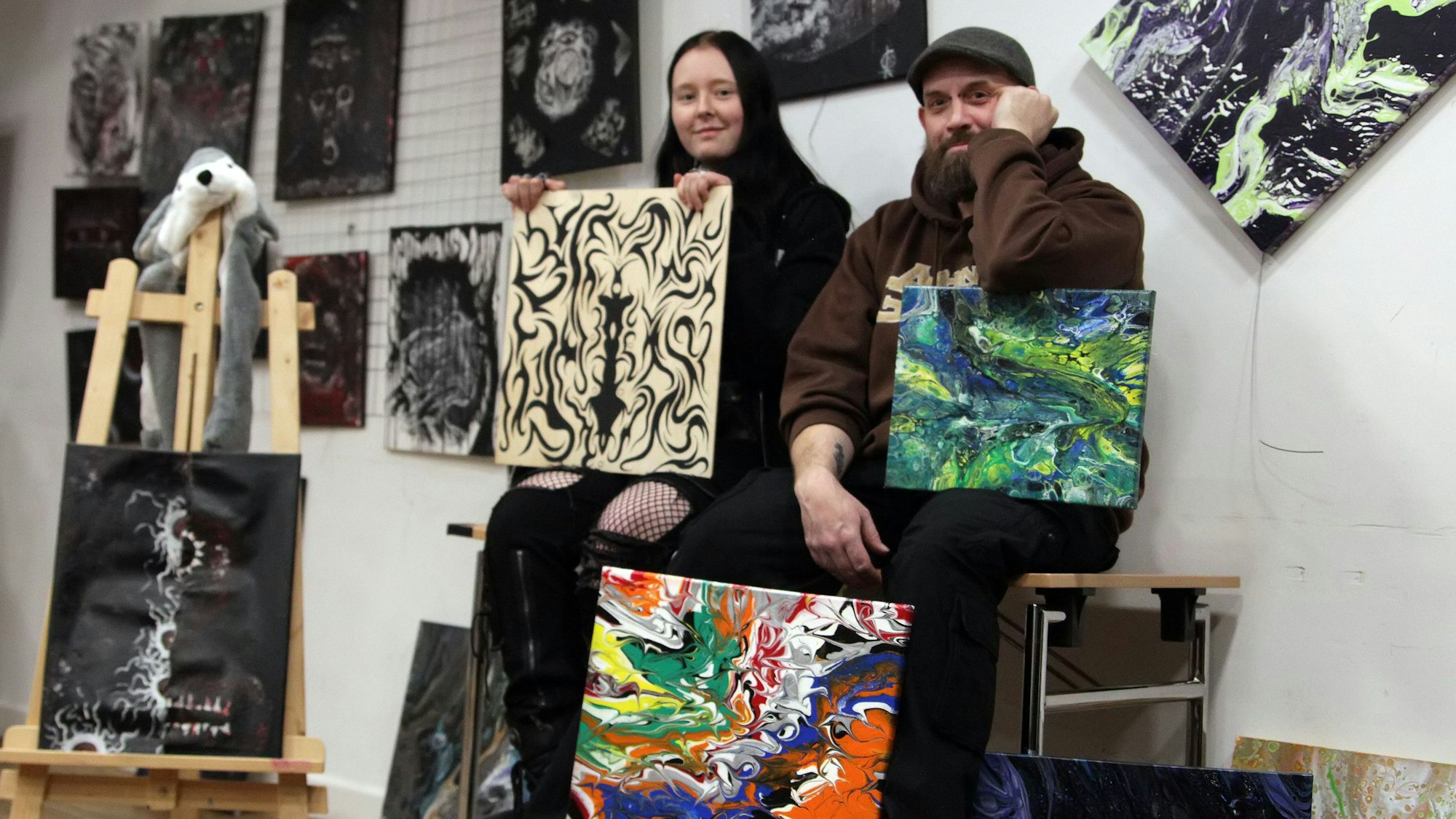 Eine junge Frau und ein Mann in einem Raum mit Bildern.