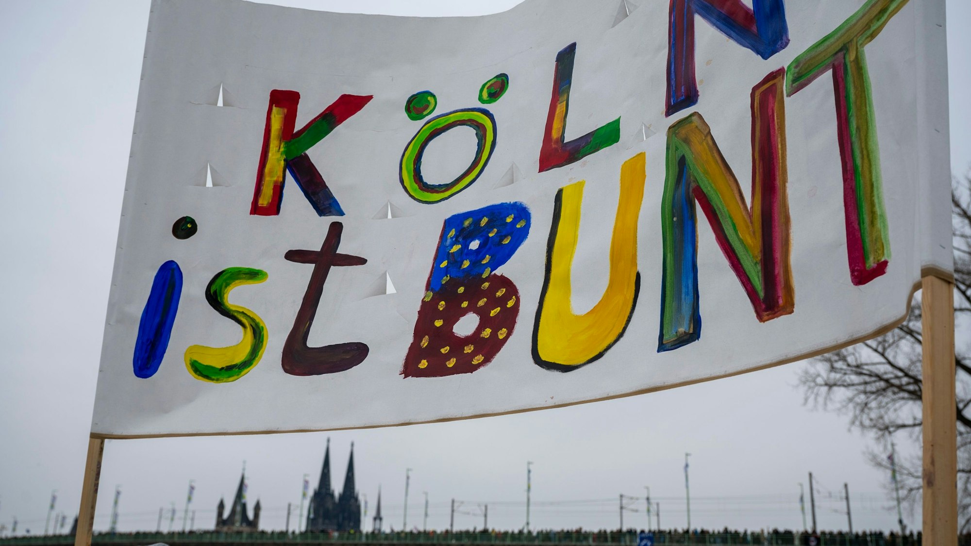 „Köln ist bunt“ steht auf einem Banner bei einer Großdemo gegen Rechts auf der Deutzer Werft im Januar 2024.