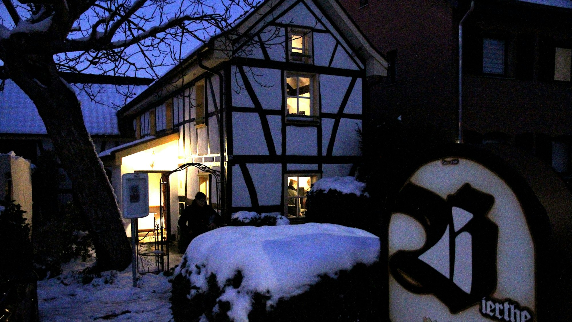 Ein erleuchtetes Fachwerkhäuschen am Abend im Schnee