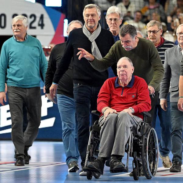 In seinem Rollstuhl, geschoben von Heiner Brand, führt Jo Deckarm die 78er Weltmeister in der Lanxess-Arena an.