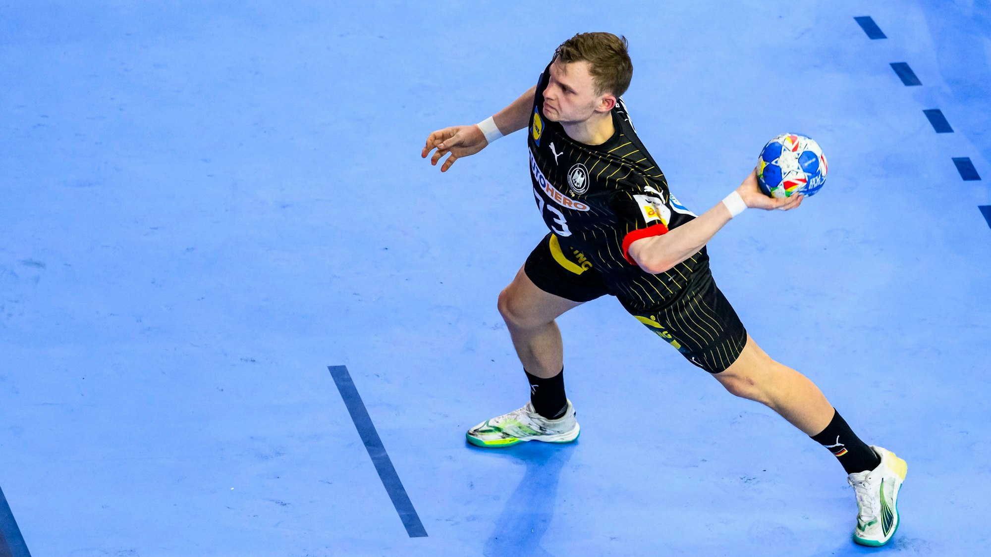 Handballer Timo Kastening holt zum Wurf mit Ball aus.