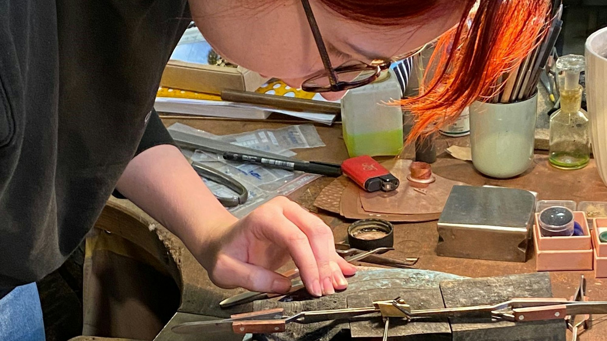 Eine Frau arbeitet an einem Werktisch.