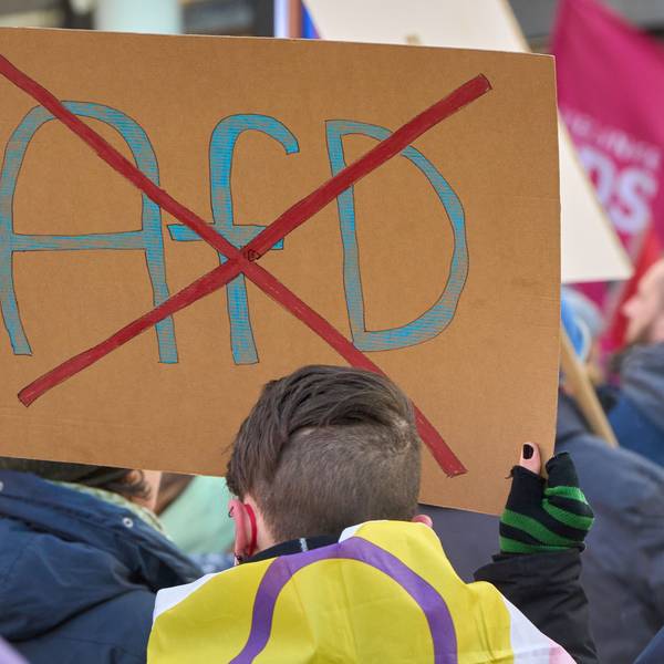 Ein durchgestrichenes AfD-Logo ist auf einem Schild bei einer Demo gegen Rechts zu sehen.