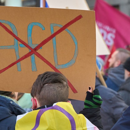 Ein durchgestrichenes AfD-Logo ist auf einem Schild bei einer Demo gegen Rechts zu sehen.