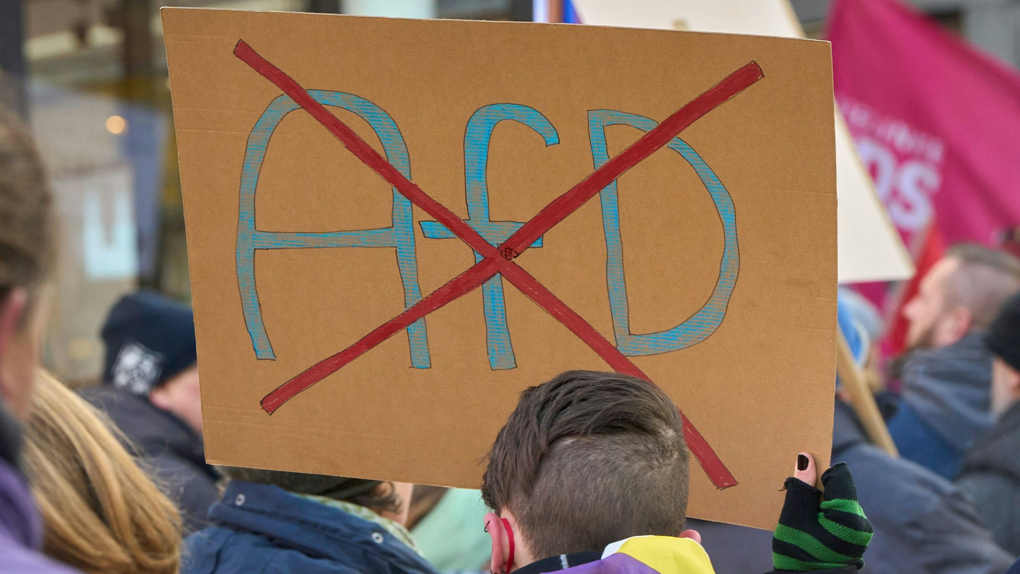 Ein durchgestrichenes AfD-Logo ist auf einem Schild bei einer Demo gegen Rechts zu sehen.