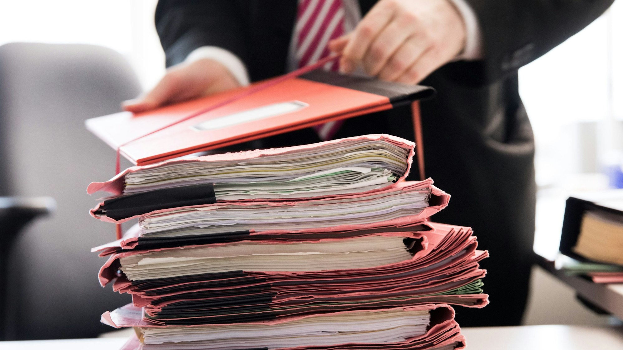 Vor dem Amtsgericht in Waldbröl musste sich jetzt ein 21-Jähriger aus Reichshof verantworten, weil am Steuer seines Wagens eingeschlafen war und einen Unfall verursacht hatte. Das Foto zeigt einen Stapel von Gerichtsakten.