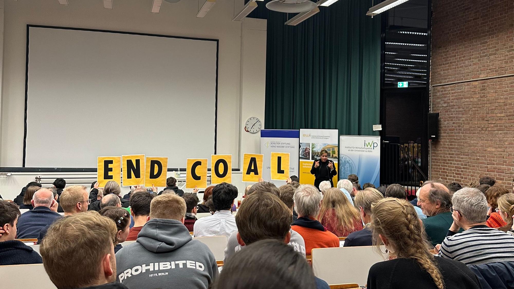 12 Mitglieder von „Scientist Rebellion“ unterbrachen den Vortrag von Mona Neubaur an der Universität zu Köln. Sie hielten dabei ein Banner mit der Aufschrift „Lützerath wurde sinnlos zerstört, Frau Neubaur“ in die Höhe.