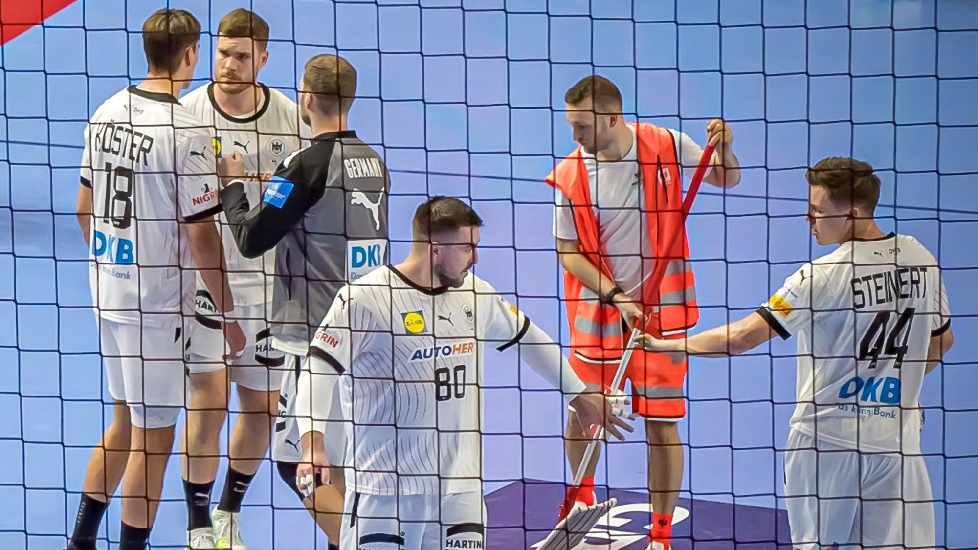Handballspieler der deutschen Nationalmannschaft stehen auf dem Feld.