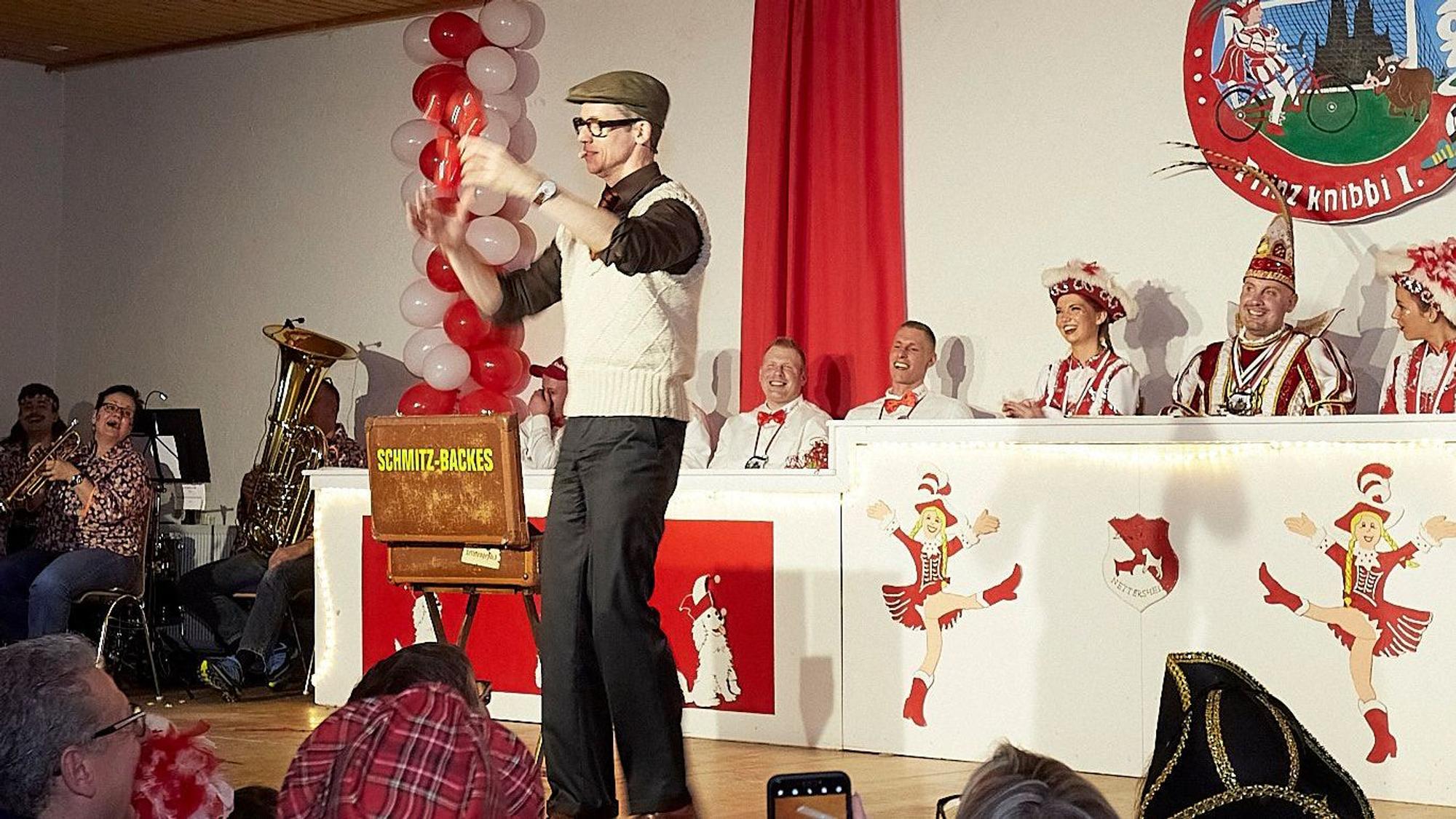 Auf der Nettersheimer Bühne produziert der Zauberer Schmitz-Backes eine Ballonfigur. Sein Publikum lacht.