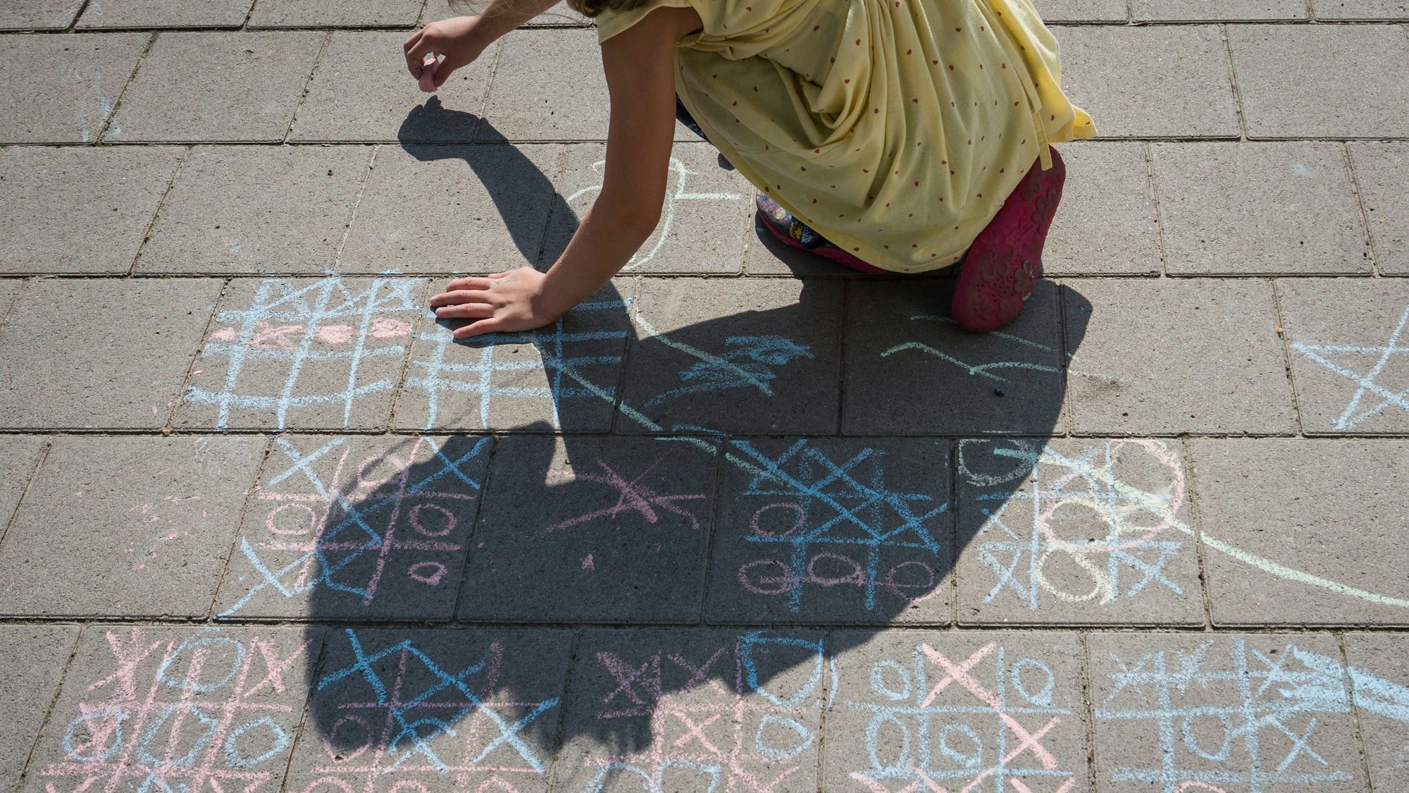 ARCHIV - 24.07.2022, Hessen, Frankfurt/Main: Ein Kind malt mit Kreide auf einem Gehweg am nördlichen Mainufer. (zu dpa «Karlsruher Entscheidung zum Kindergeld-Anspruch von Ausländern») Foto: Frank Rumpenhorst/dpa +++ dpa-Bildfunk +++