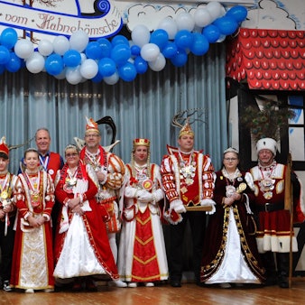Tollitäten aus dem Kaller Gemeindegebiet posieren kostümiert mit Bürgermeister Hermann-Josef Esser in der Schevener Dorfhalle.
