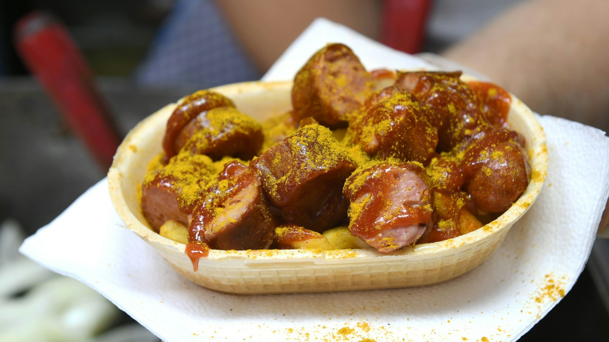 Eine Currywurst wird in einer essbaren Schale verkauft.
