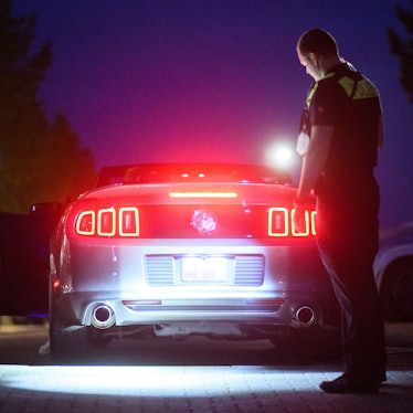 Ein Polizist bei einer Kontrolle auf einem Treffen von Autoposern.