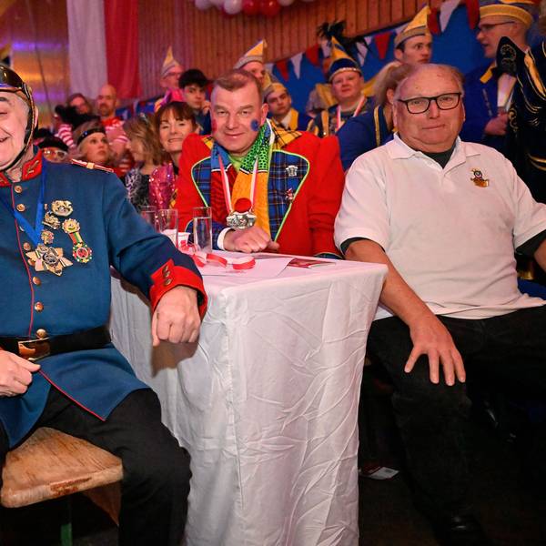 NRW-Innenminister Herbert Reul sitzt mit Tanja Paas vom Festkomitee der Karnevalsfreunde Oberodenthal kostümiert in der Prunksitzung in Oberodenthal.